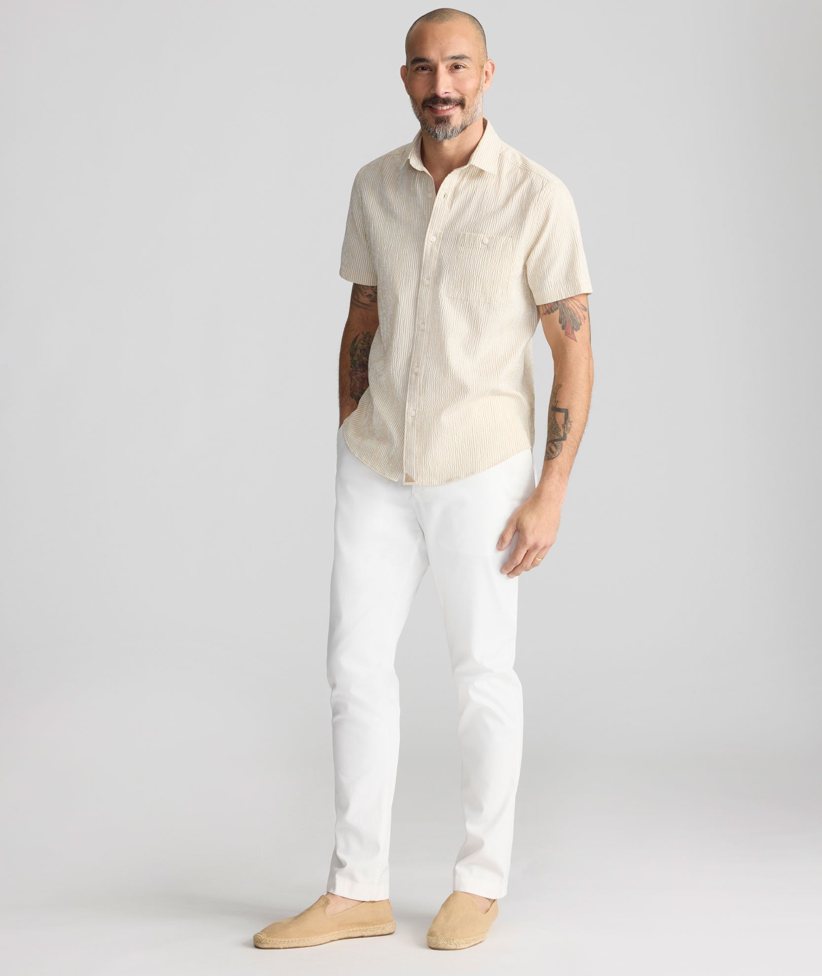 Model is wearing UNTUCKit Stretch Cotton Hybrid Pant in Cream. 