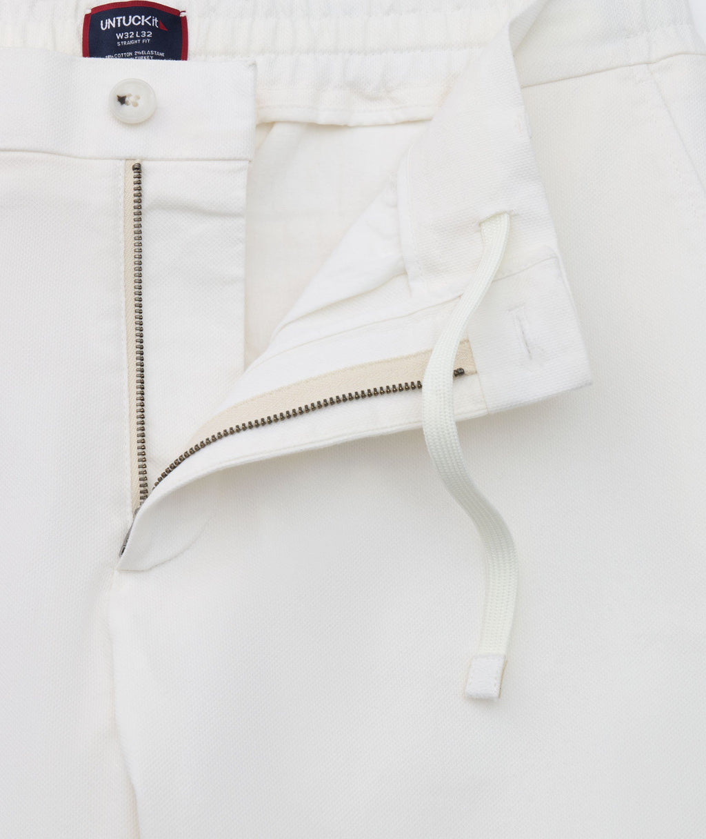 Model is wearing UNTUCKit Stretch Cotton Hybrid Pant in Cream. 