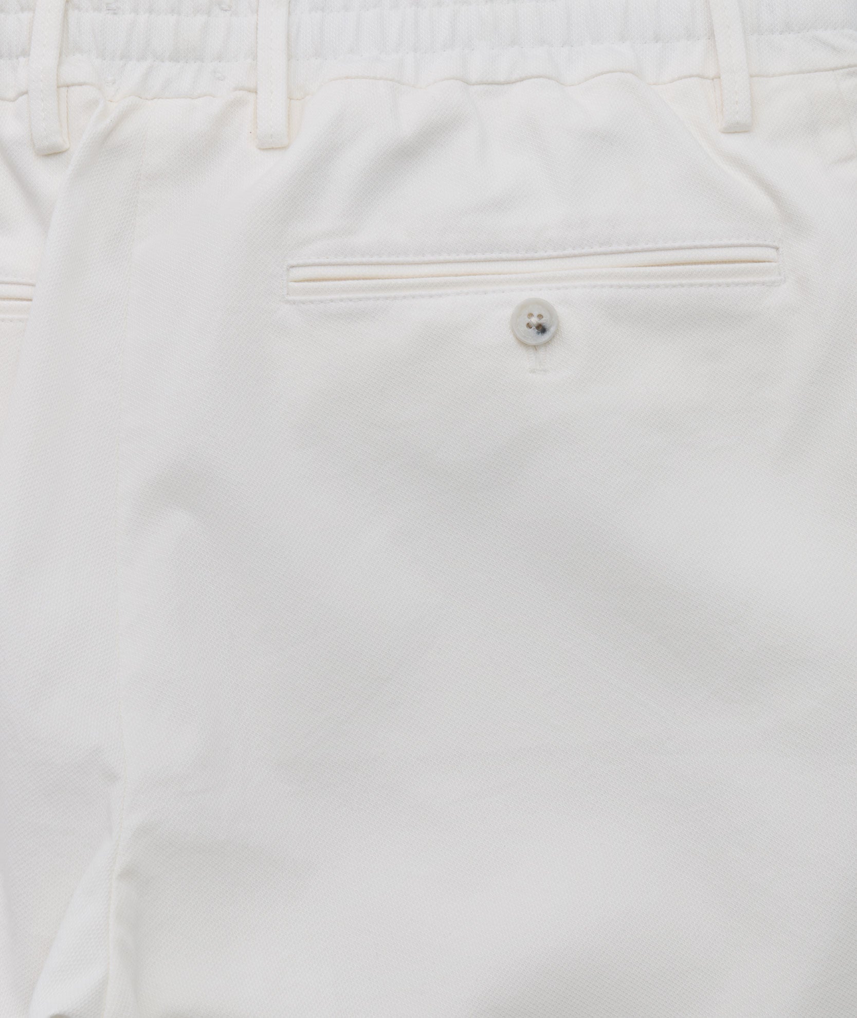 Model is wearing UNTUCKit Stretch Cotton Hybrid Pant in Cream. 