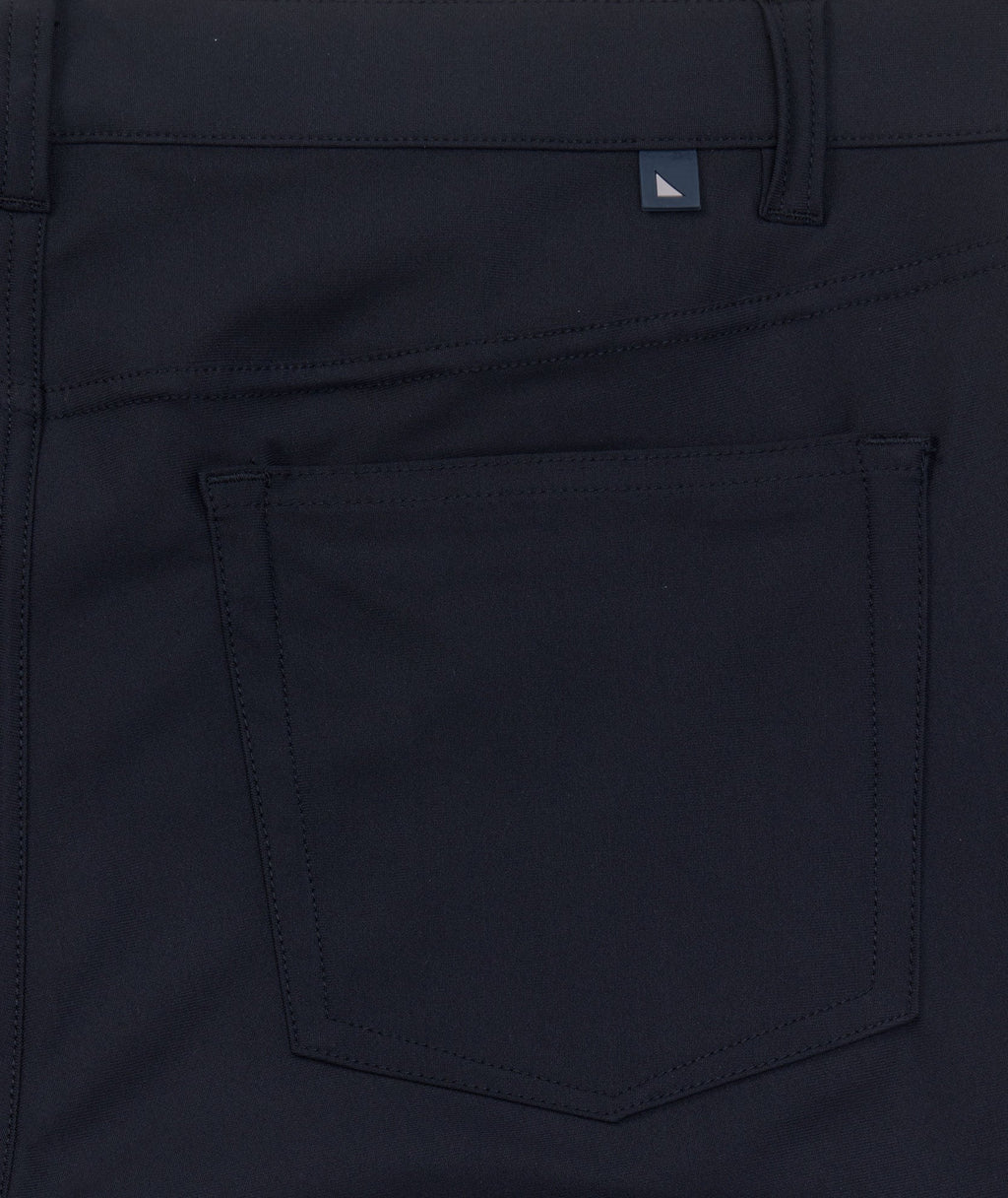 Model is wearing UNTUCKit Torre 5-Pocket Tech Pant in Black. 