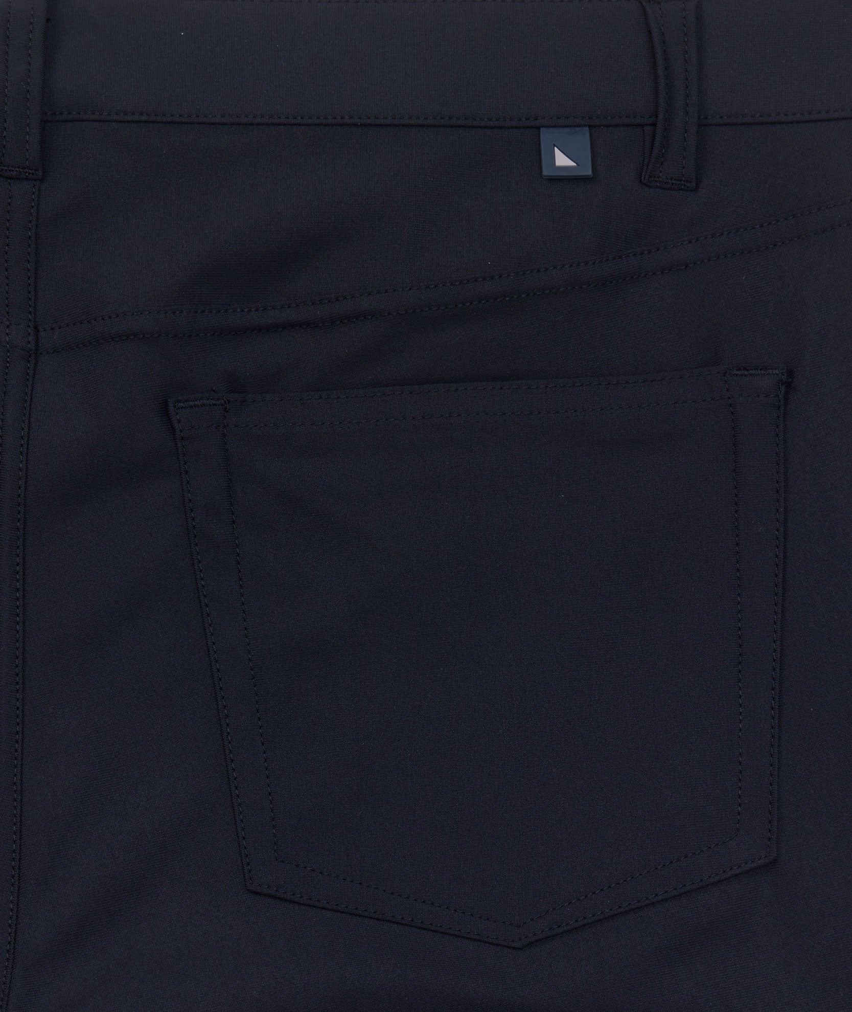 Model is wearing UNTUCKit Torre 5-Pocket Tech Pant in Black. 