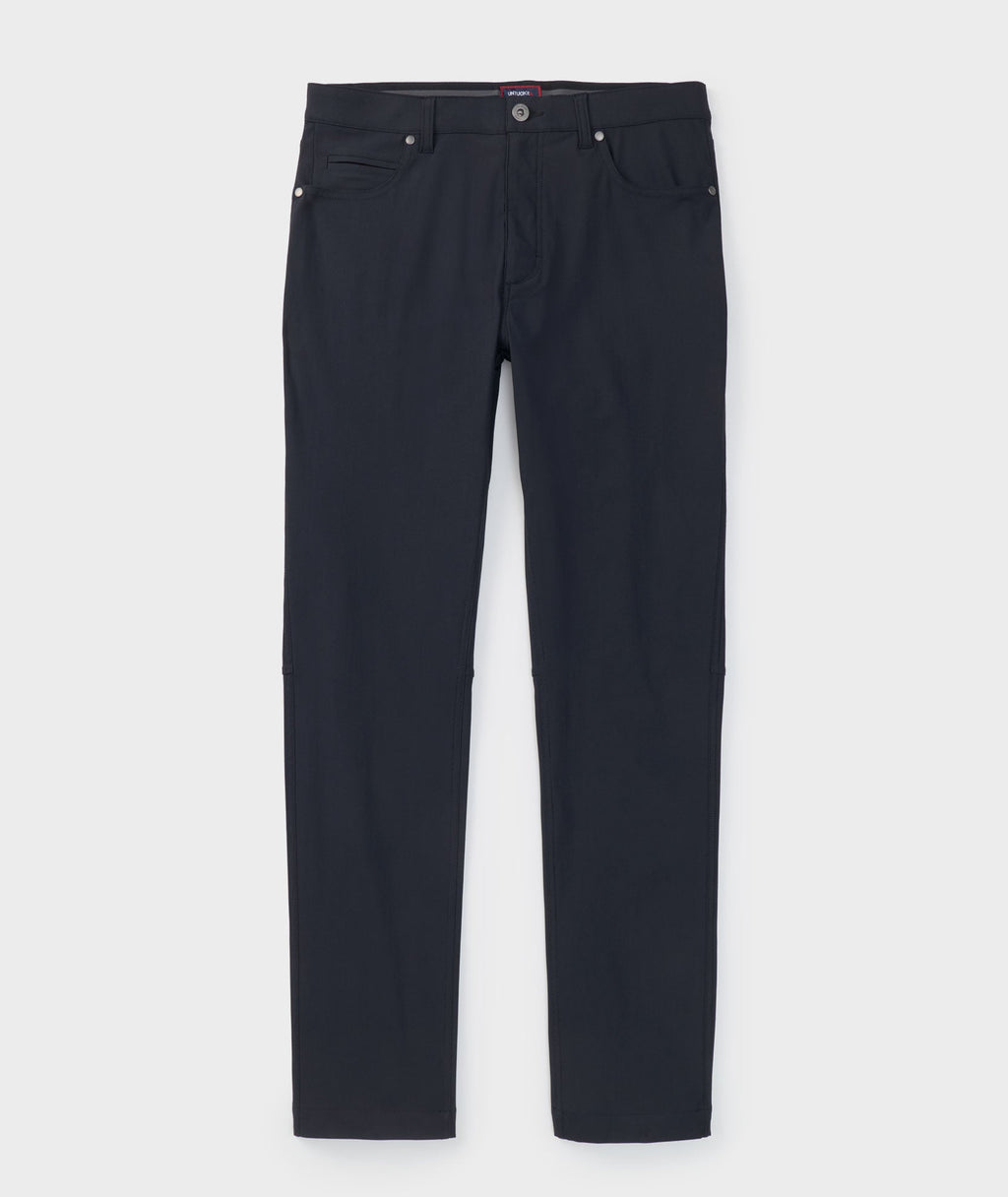 Model is wearing UNTUCKit Torre 5-Pocket Tech Pant in Black. 
